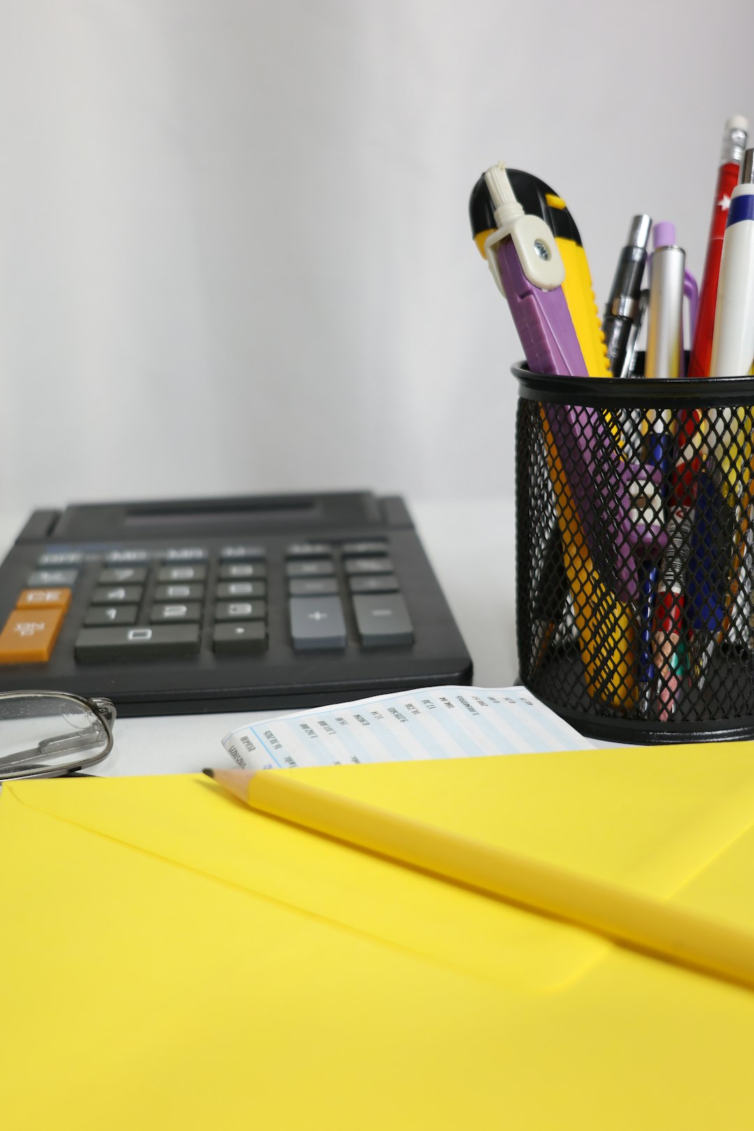 desk-with-calculator-pens-and-yellow-envelope-uuxwegwkigk